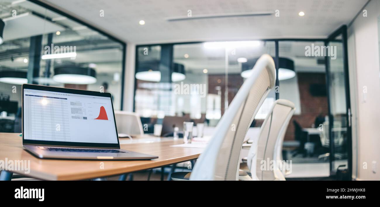 Standbild eines Laptop-Bildschirms mit grafischen Daten. Aufnahme eines Laptops auf einem Tisch in einem Sitzungssaal. Stockfoto