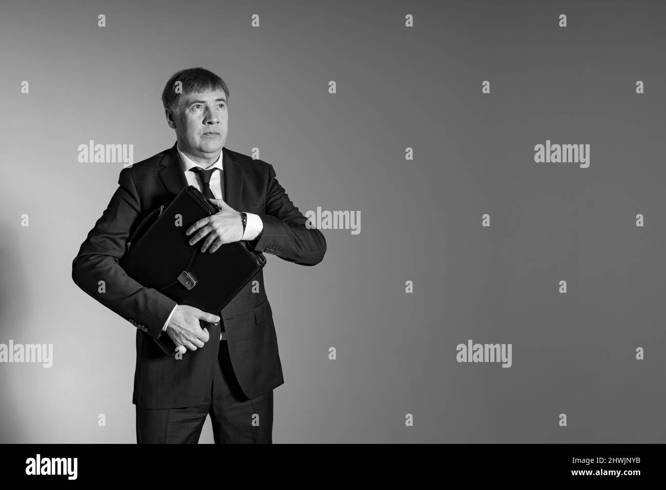 Konzeptuelles Bild eines Geschäftsmannes mit Aktentasche auf grauem Hintergrund Stockfoto