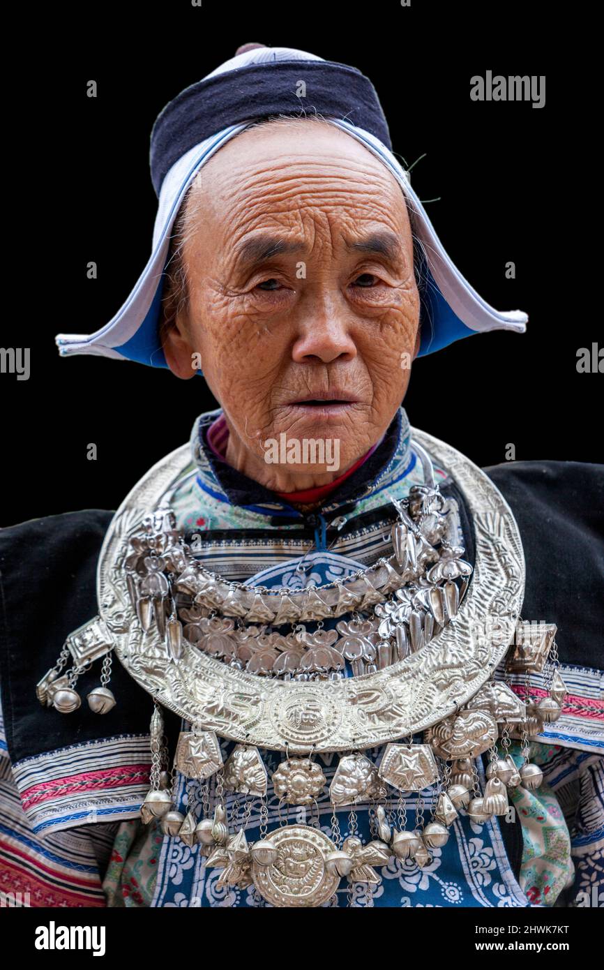 Matang, einem Gejia Dorf in Guizhou, China.  Frau mittleren Alters in traditioneller Kleidung, Kopfbedeckung und Halskette. Stockfoto