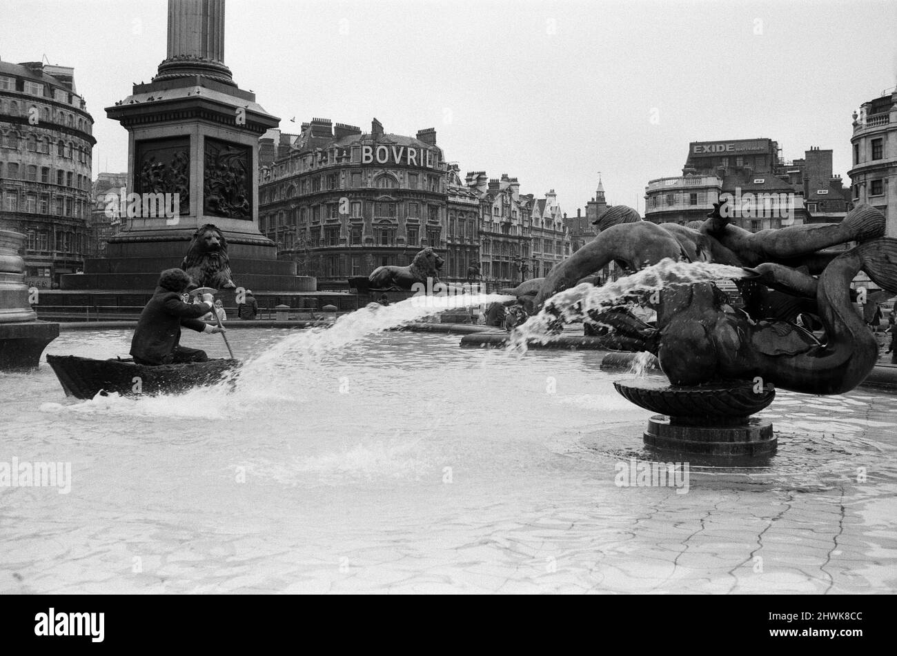 Coracle Fishermen in London. Einer der Fischer paddelt zum Interesse der Besucher sein Corakel um den Trafalgar Square Brunnen. 1.. April 1972. Stockfoto