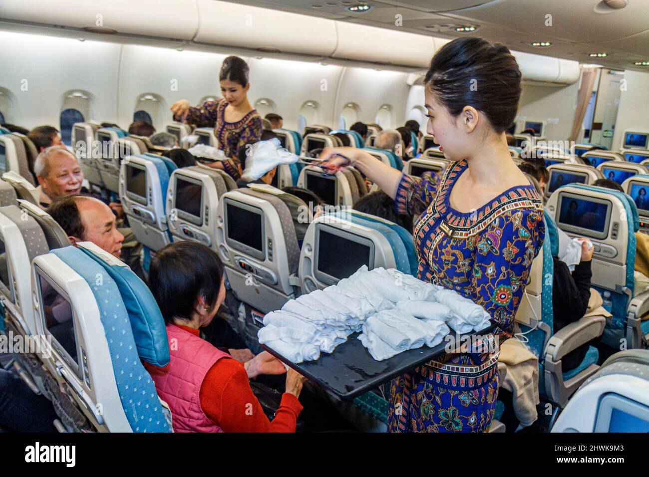 San Francisco, Kalifornien, Internationaler Flughafen, Abflug von Singapore Airlines, weibliche asiatische Flugbegleiterinnen, die Fluggäste mit heißen Handtüchern bewirten Stockfoto