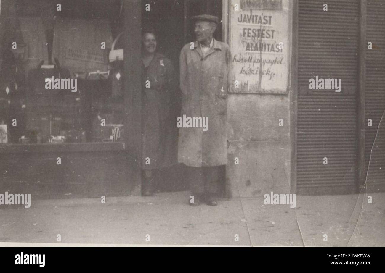 Vintage-Schwarz-Weiß-Foto über einen ungarischen Handwerker und seine Frau, die vor dem Ladeneingang am 1930s stehen. ADDITIONAL-RIGHTS-CLEARANCE-INFO-NOT-AVAILABLE Stockfoto