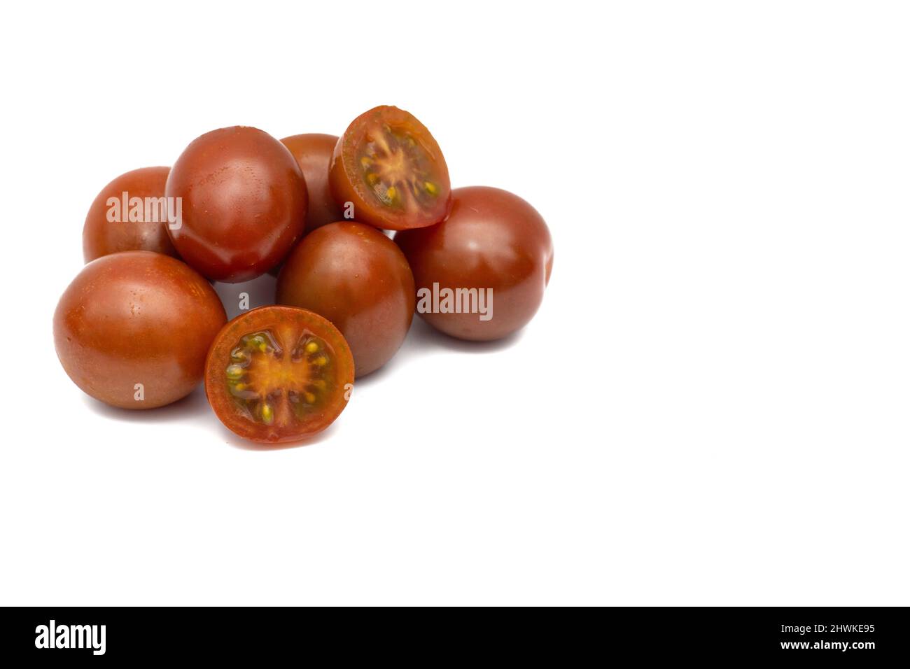 Eine Charge Kirschtomaten, die Mini-Kumato-Sorte. Isoliert auf weißem Hintergrund. Stockfoto