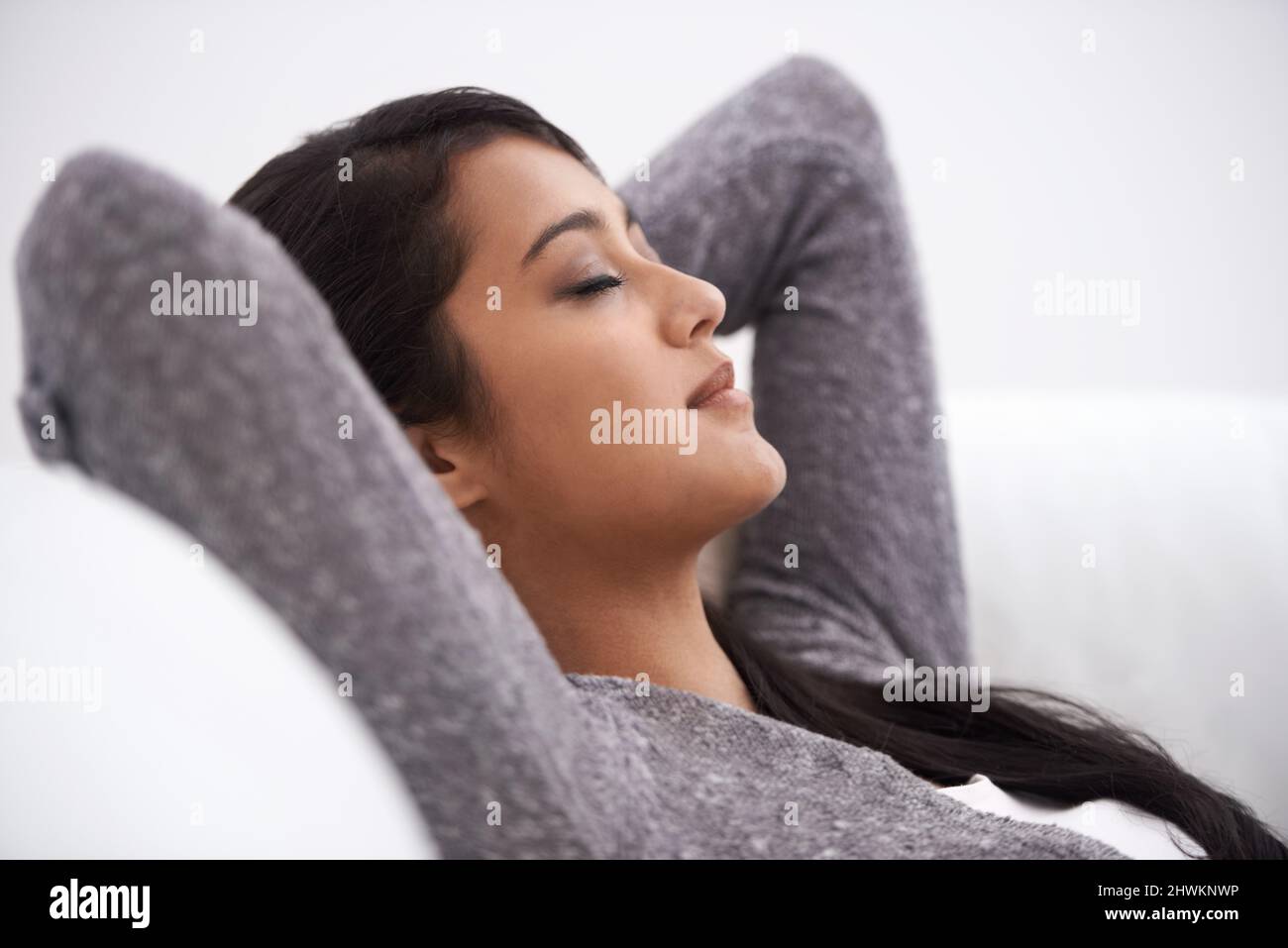 Eine Pause einlegen. Eine junge Frau, die ein Nickerchen auf ihrem Sofa macht. Stockfoto