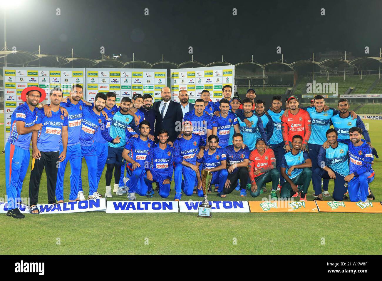 Dhaka, Bangladesch. 05. März 2022. Nach dem zweiten internationalen Cricket-Spiel Twenty20 zwischen Bangladesch und Afghanistan im Sher-E-Bangla National Cricket Stadium posieren Spieler aus Bangladesch und Afghanistan zusammen mit Teambeamten für ein Gruppenfoto mit einer Trophäe. Afghanistan gewann mit 8 Wickets (mit noch 14 Bällen) (Foto: MD Manik/SOPA Images/Sipa USA) Credit: SIPA USA/Alamy Live News Stockfoto