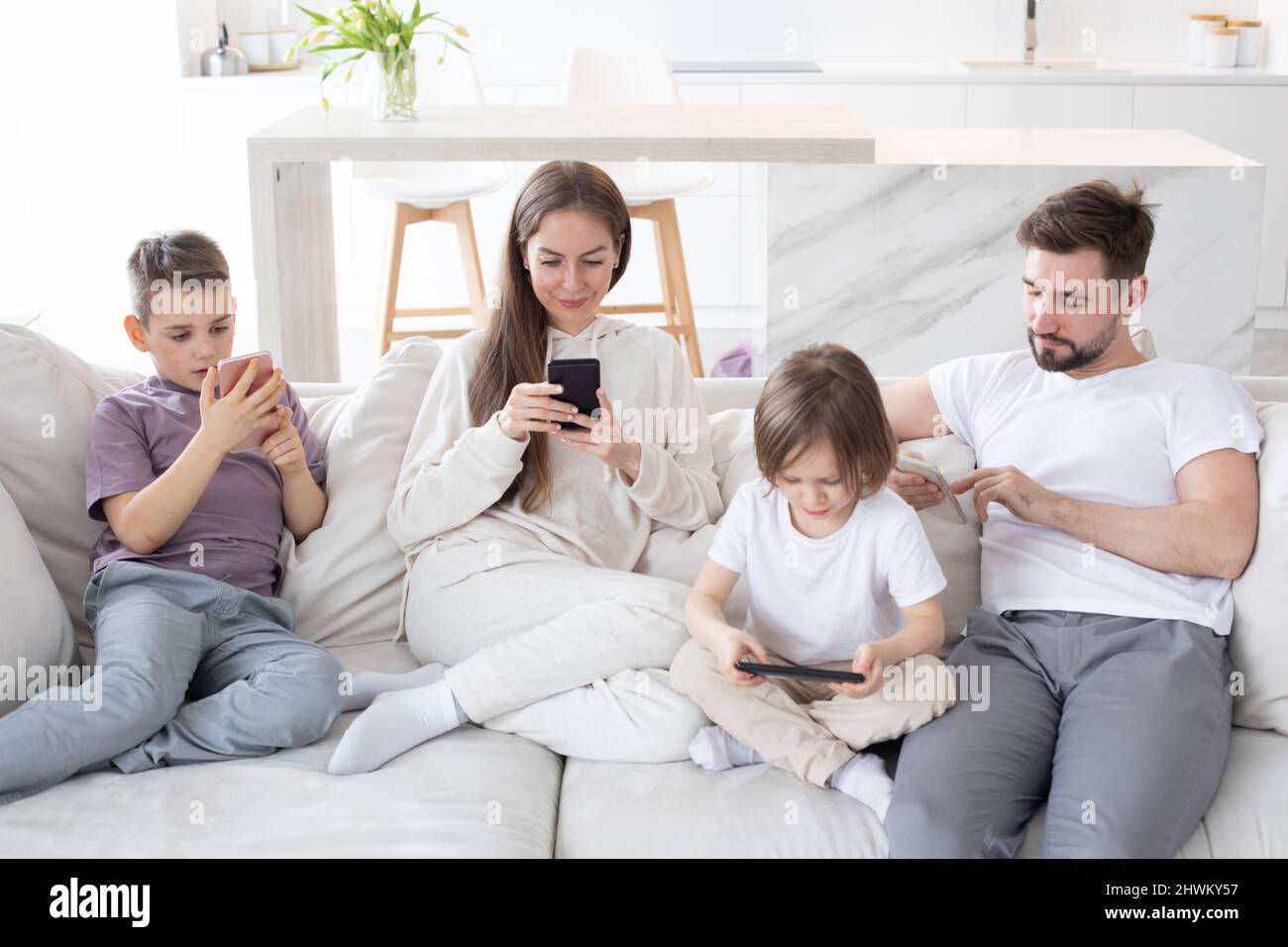 Porträt der Familie mit zwei Kindern, die das elektronische Smartphone in den Händen halten SMS mit wi-Fi 5G Internet-Check-E-Mail-Suche Co Stockfoto