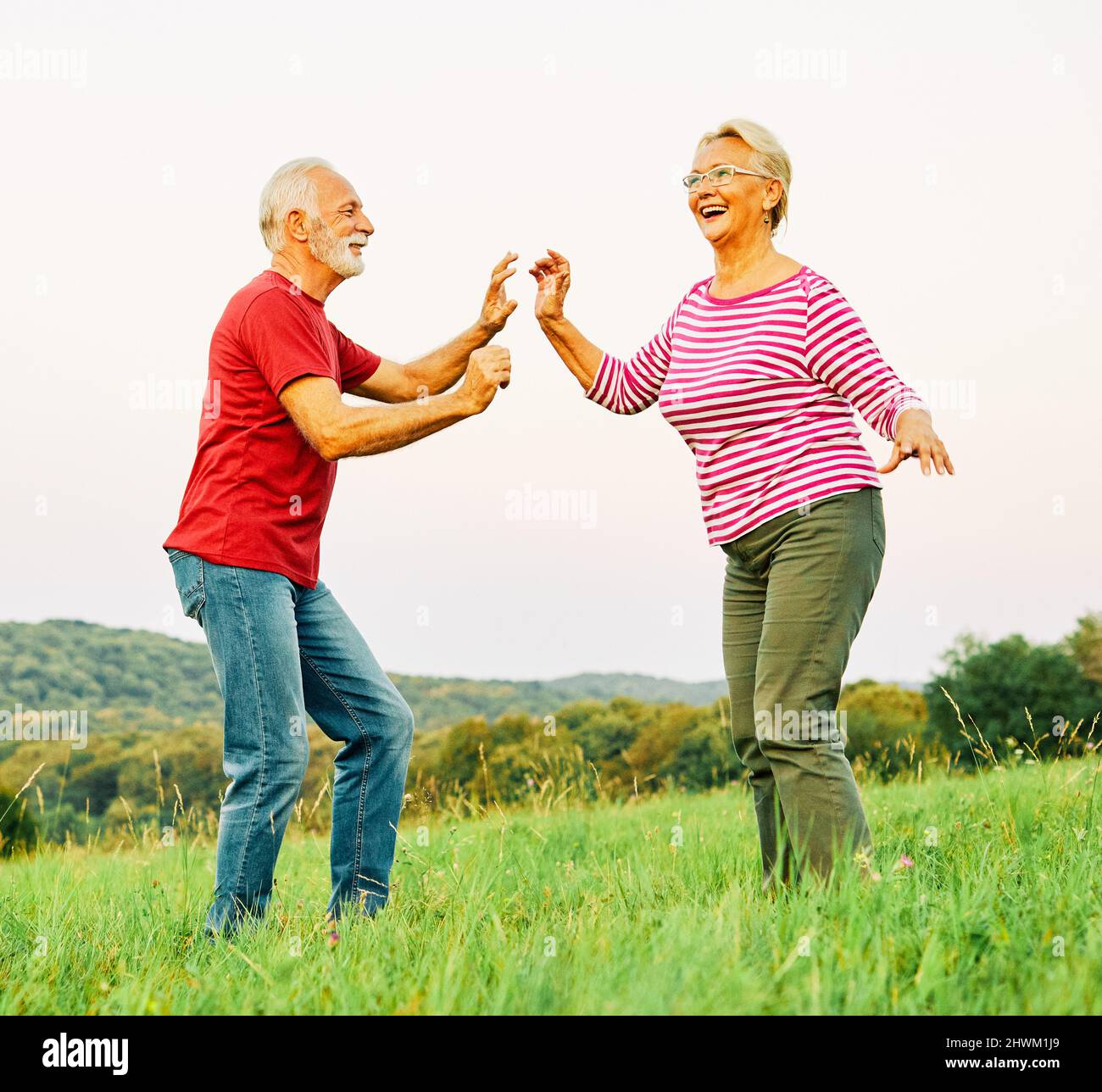 Frau Mann Outdoor Senior Paar glücklich ältere Ausbildung aktive Übung Stretching Fitness Ruhestand zusammen lieben tanzen Natur reifen Stockfoto