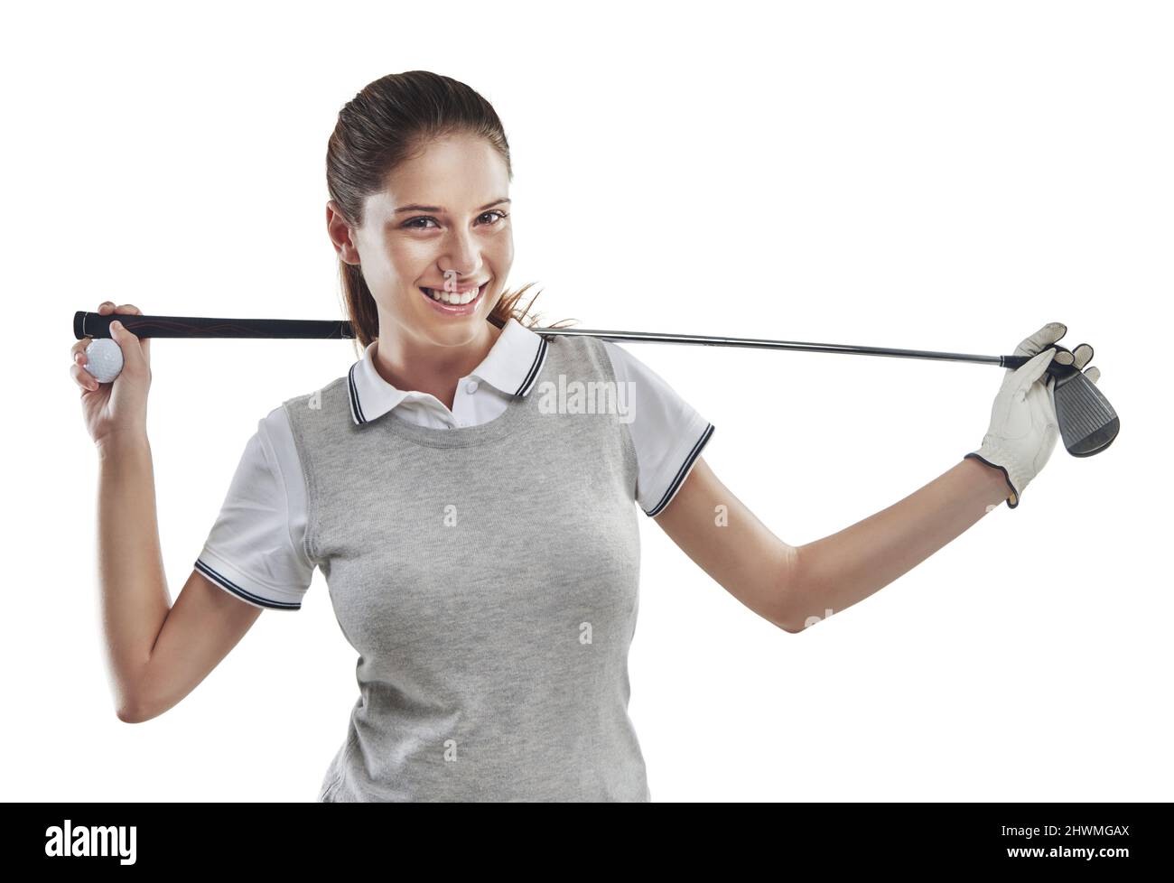 Golf gibt gute Stimmung. Studioaufnahme einer jungen Golferin, die einen Golfschläger hinter ihrem Rücken in Weiß gehalten hat. Stockfoto