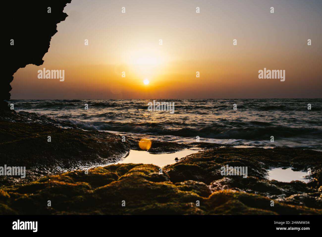 Goldener Sonnenuntergang über dem Meer und den Gezeitenpools des Korallenriffs Stockfoto