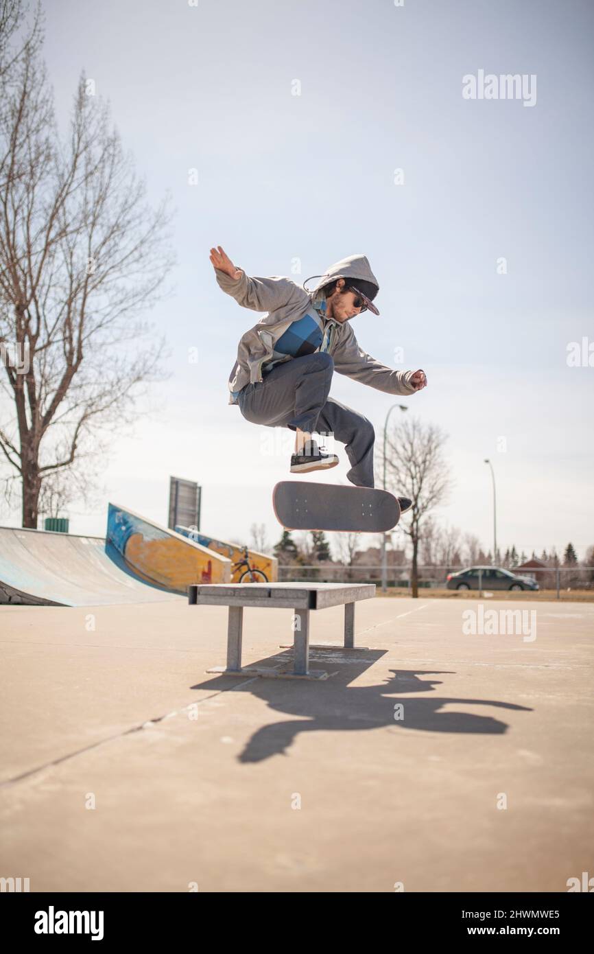 Junger Skateboard-Enthusiast, der einen Kickflip macht Stockfoto