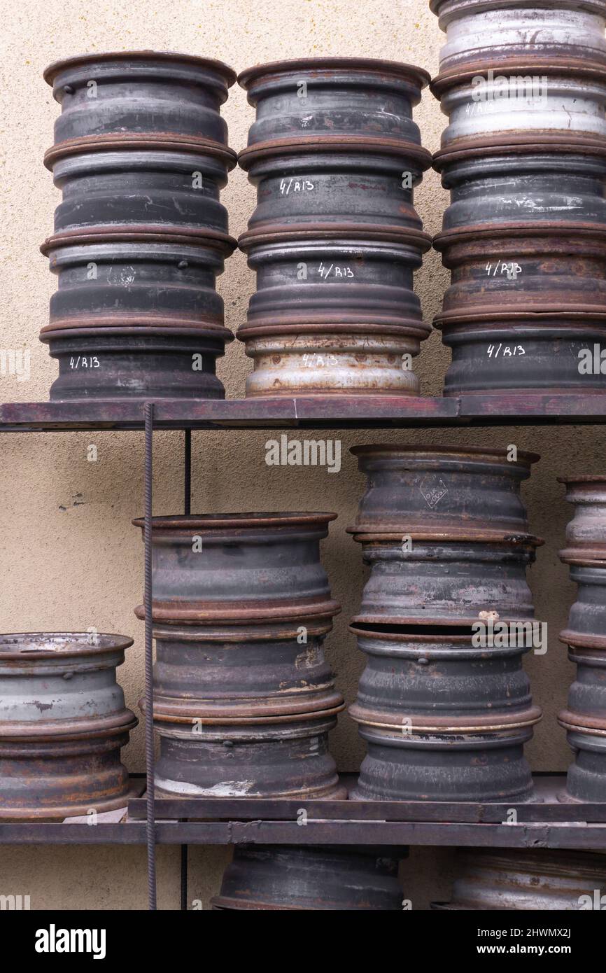 Alte rostige Metallwagenfelgen in einer Garage gefaltet Stockfoto
