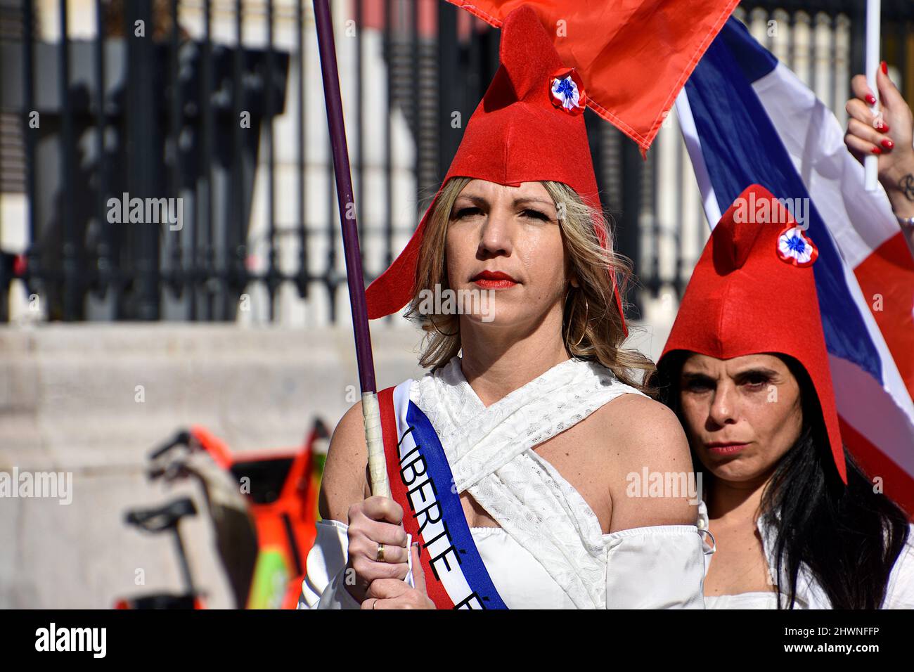 Marseille, Frankreich. 26.. Februar 2022. Frauen, die als „Marianne“ mit phrygischen Mützen gekleidet sind, halten während der Demonstration französische Flaggen. Frauen, die als „Marianne“ (Symbol der Freiheit in Frankreich) gekleidet sind, demonstrieren in Marseille gegen drakonische Maßnahmen wie den von der französischen Regierung verhängten Impfpass. Kredit: SOPA Images Limited/Alamy Live Nachrichten Stockfoto