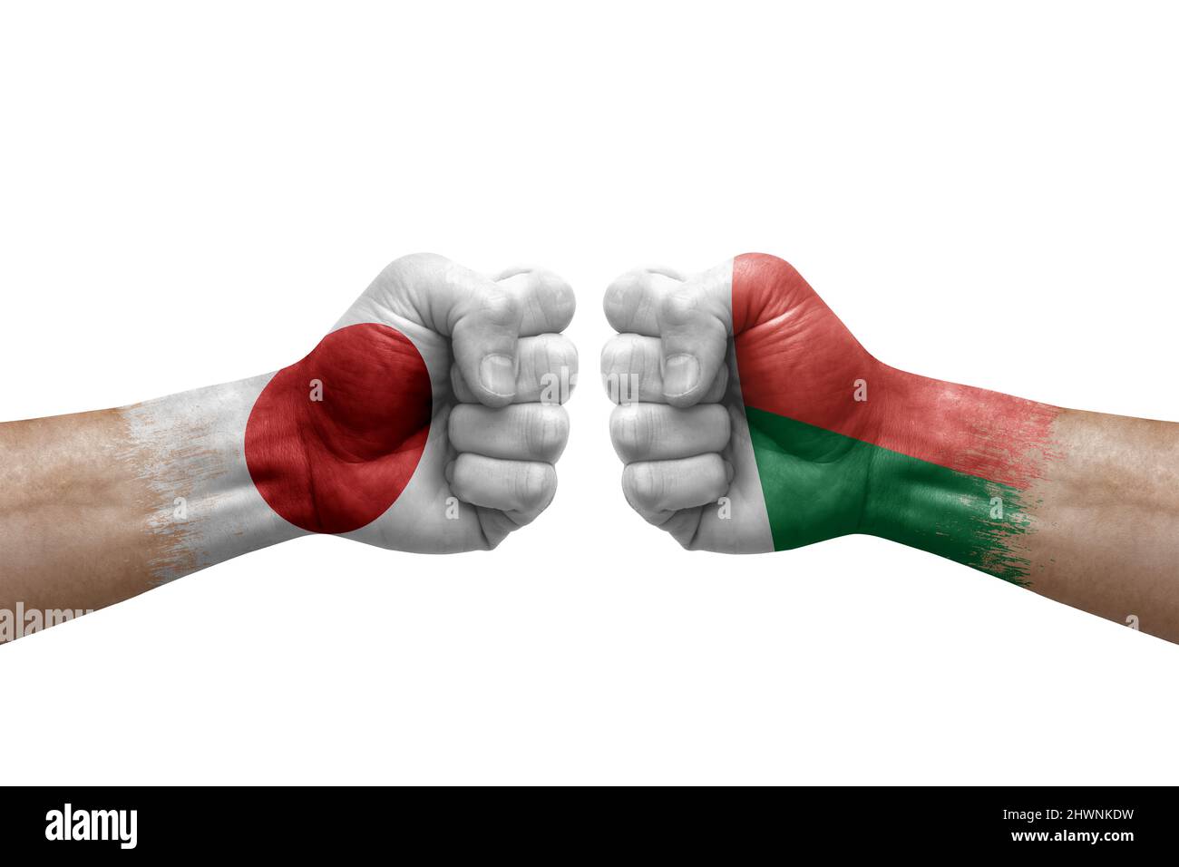 Zwei Hände schlagen sich gegenseitig auf weißem Hintergrund zu. Länderflaggen bemalten Fäuste, Konfliktkrisenkonzept zwischen japan und madagaskar Stockfoto