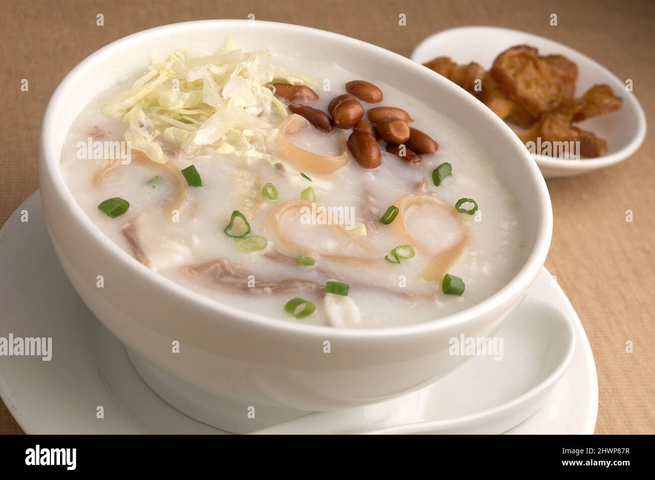 Congee mit Schweinefleisch, Erdnuss und Krulleröl Stockfoto