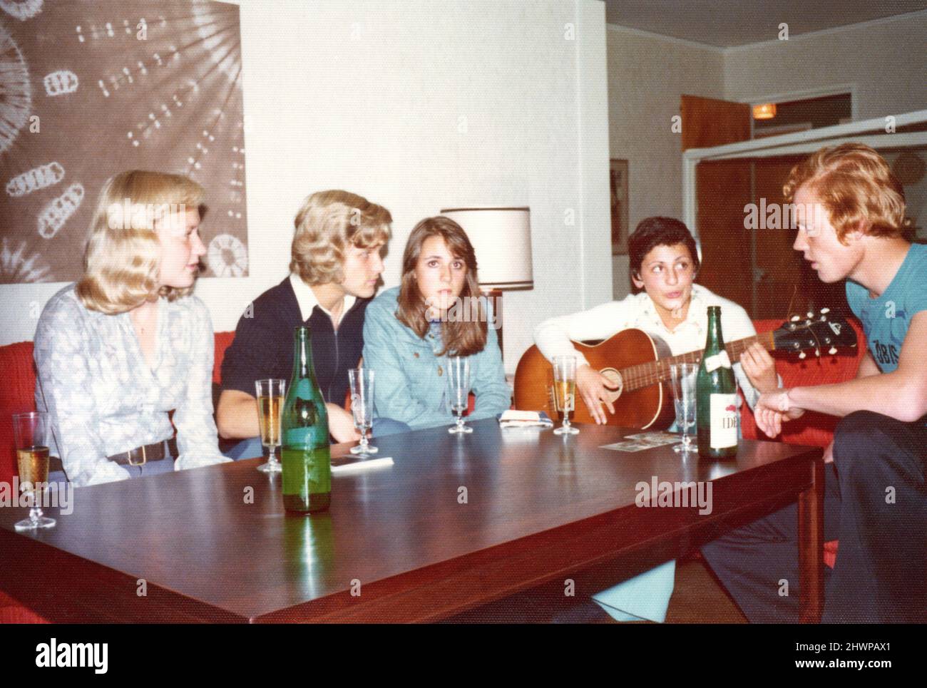 Originalfoto der 1970er Jahre von einer Gruppe schwedischer Teenager, die reden, trinken und Gitarre spielen, Schweden. Konzept von Freundschaft, Zweisamkeit, Nostalgie Stockfoto