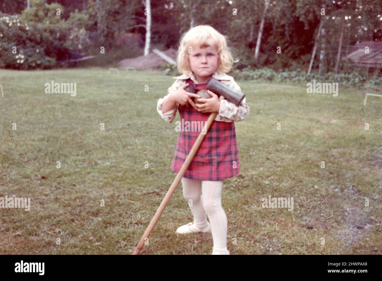 Original-Farbfoto der 1970er Jahre von einem kleinen blonden Mädchen, das Krocketschläger und Kugeln hält, Schweden. Stockfoto