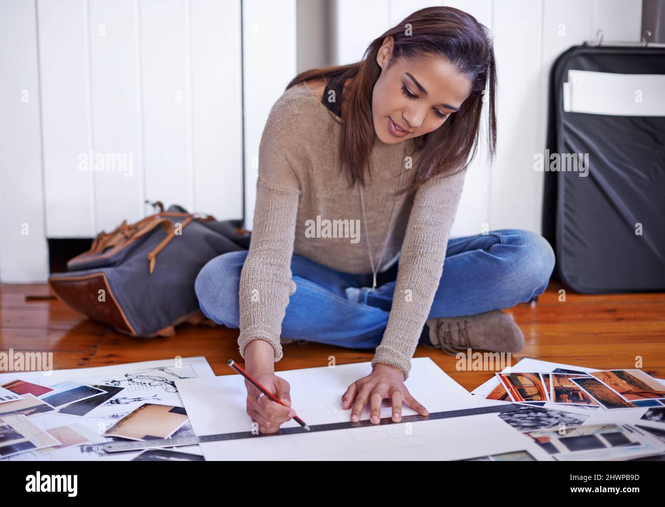 Arbeiten an der Entwicklung ihres Portfolios. Eine junge Frau, die zu Hause an ihrem Portfolio arbeitet. Stockfoto