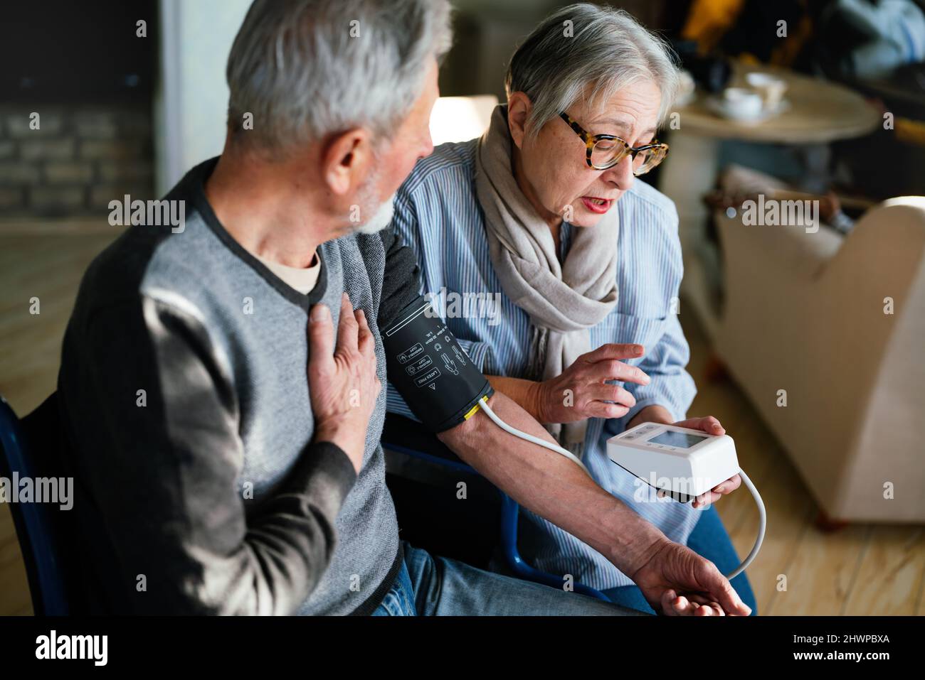 Seniorenpaar zu Hause, das den Blutdruck misst. Home Monitoring People Healthcare Konzept Stockfoto