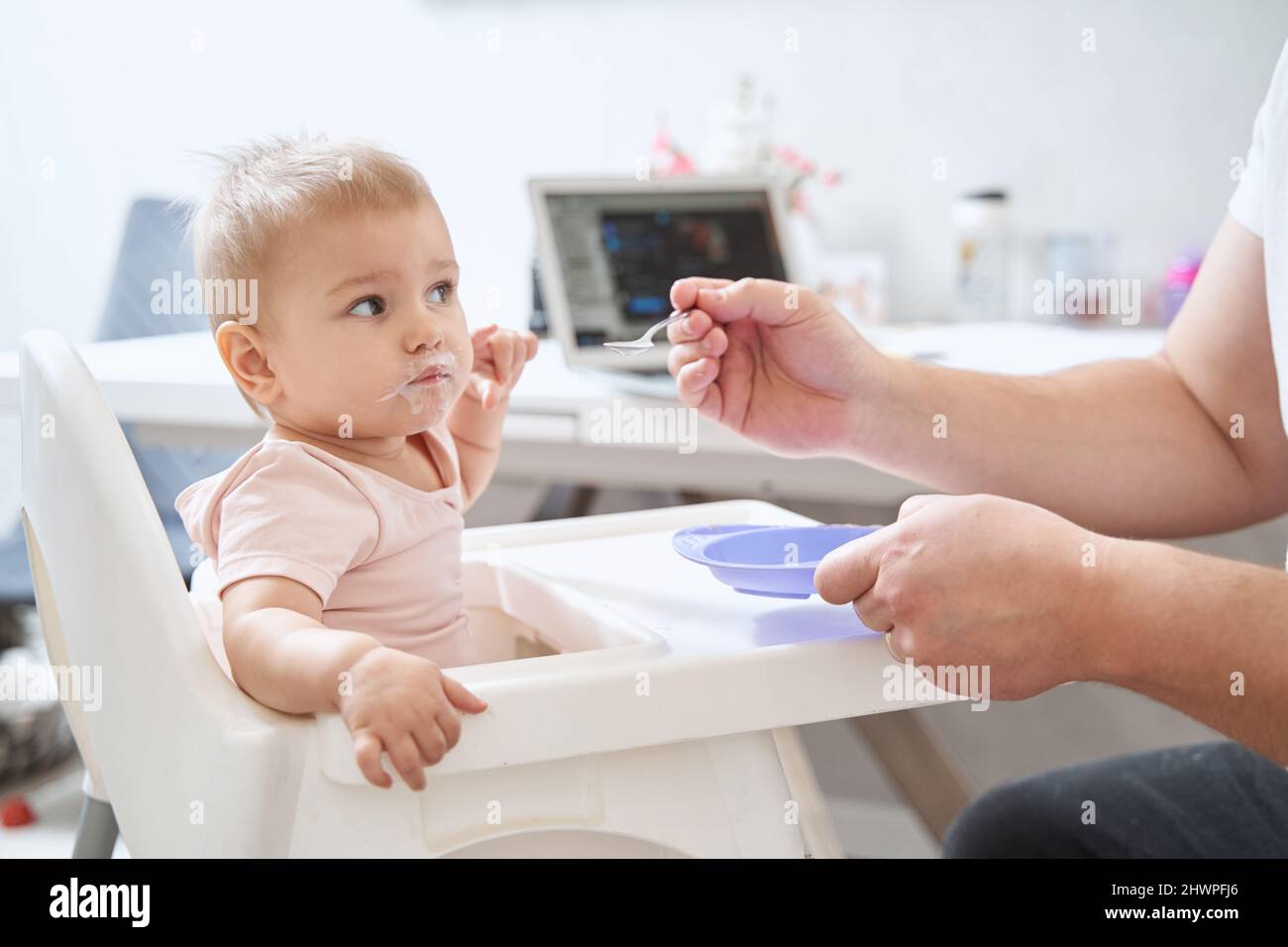 Eltern füttern das Baby mit Grießpudding Stockfoto