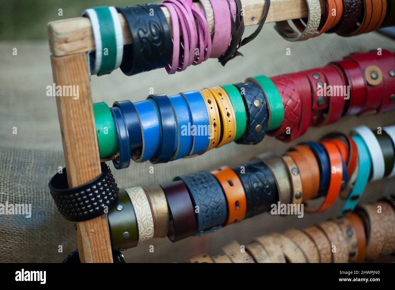 Lederarmbänder. Verkauf von Schmuck für Frauen. Hausgemachte Armbänder aus Leder in verschiedenen Farben gefärbt. Details des Handels mit Dingen auf dem Festival. Stockfoto