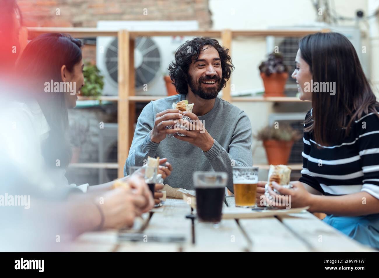 Fröhliche Geschäftsmänner und Geschäftsfrauen, die Burritos in der Bürokantine hatten Stockfoto