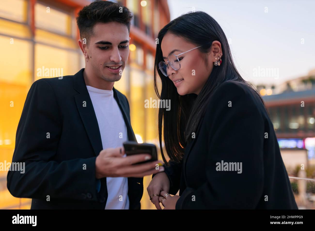 Geschäftsmann, der einer Geschäftsfrau in der Stadt ein Smartphone zeigt Stockfoto