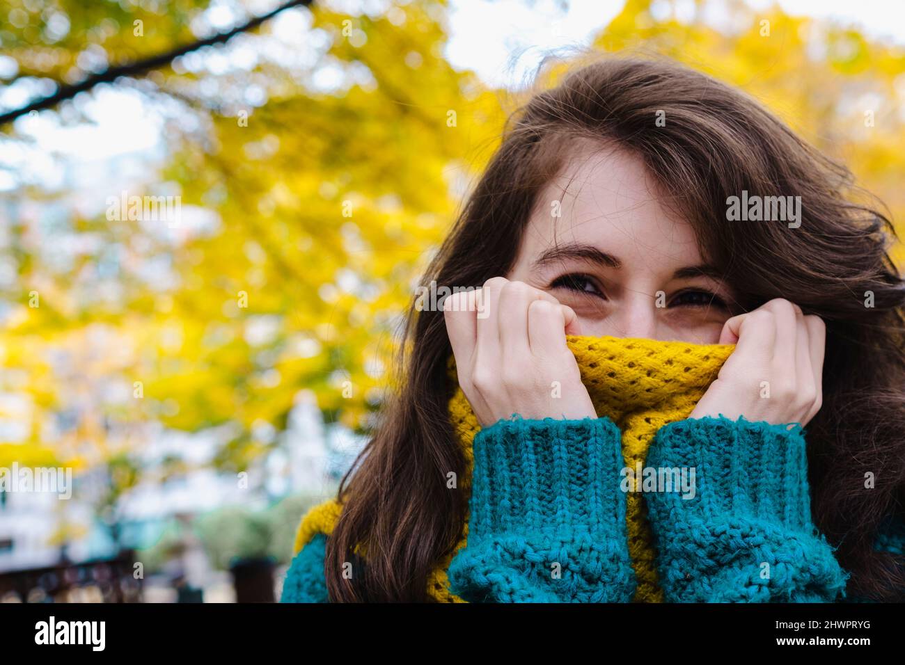 Frau bedeckt den Mund mit Schal im Park Stockfoto