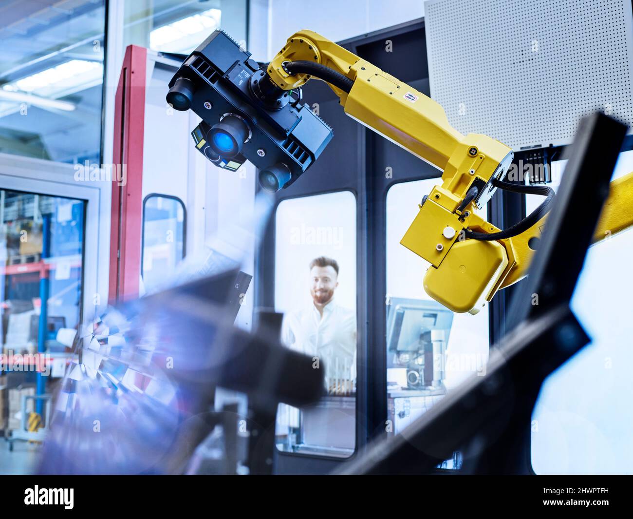 Ingenieur, der im Werk einen Vermessungsroboter mit 3D Scans ansieht Stockfoto