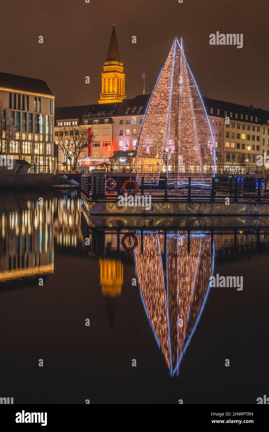 Deutschland, Schleswig-Holstein, Kiel, großer Weihnachtsbaum, der sich nachts im Stadtkanal spiegelt Stockfoto