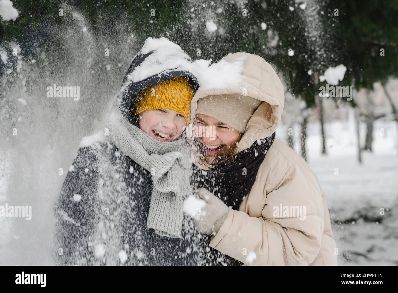Fröhlicher Sohn und Mutter genießen im Schnee Stockfoto