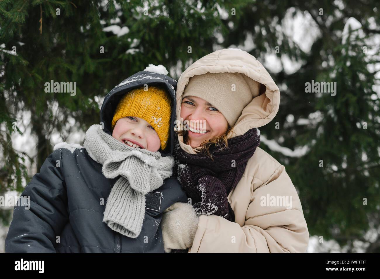 Glückliche Mutter und Sohn zusammen im Winterwald Stockfoto