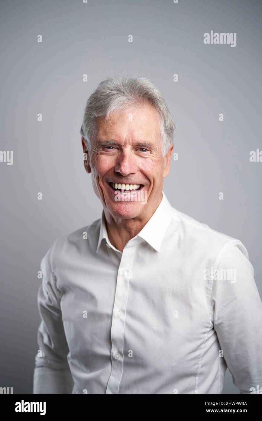 Leitender Geschäftsmann, der im Studio lacht Stockfoto