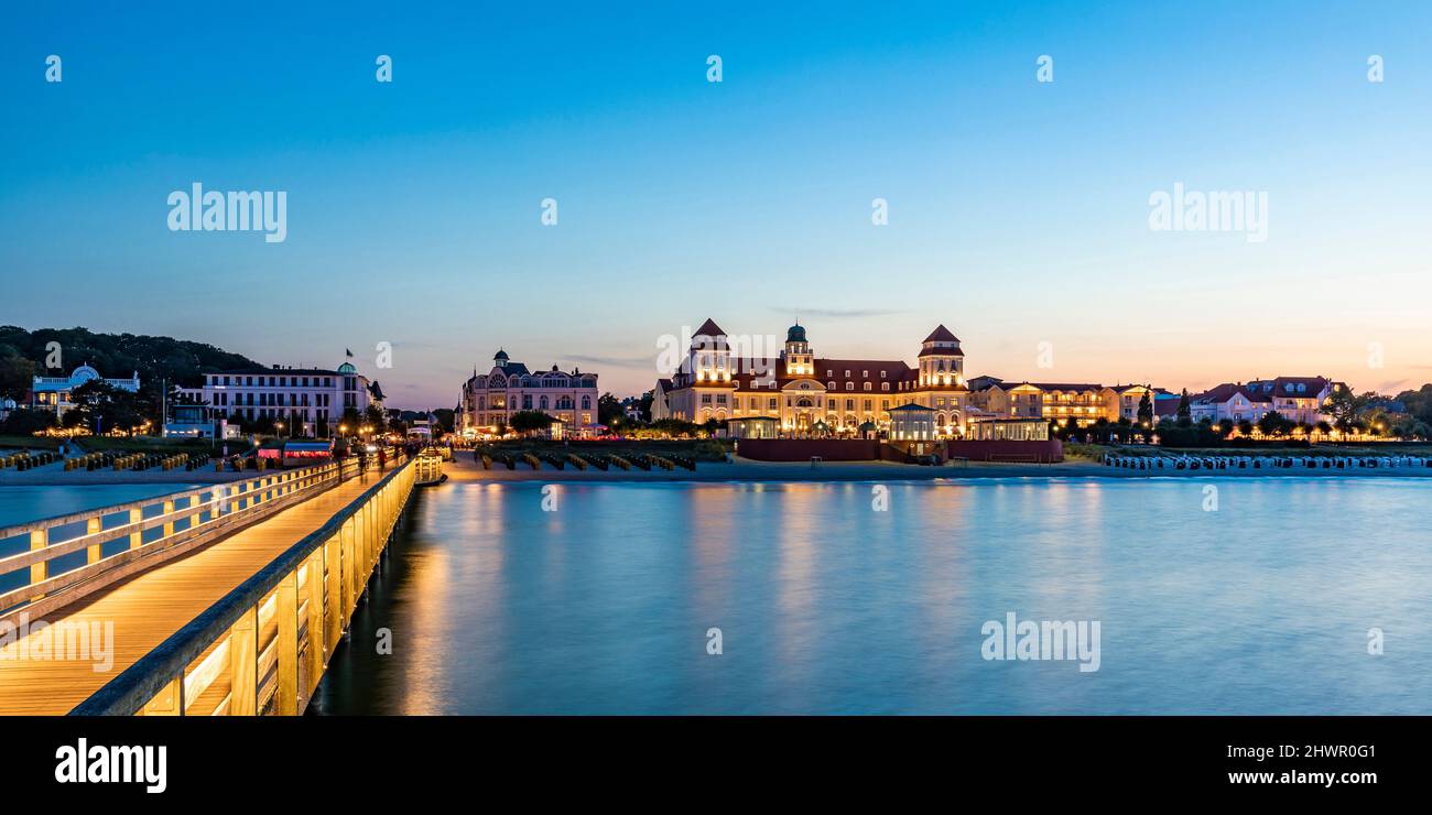 Deutschland, Mecklenburg-Vorpommern, Binz, leerer Pier in der Abenddämmerung mit Kurhaus Binz Resort Hintergrund Stockfoto