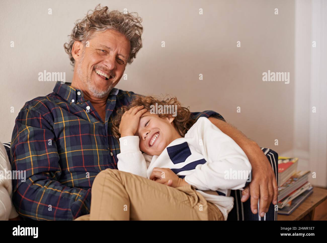 Mit Großvater lachen. Porträt eines Großvaters, der in Innenräumen Zeit mit seinem Enkel verbringt. Stockfoto