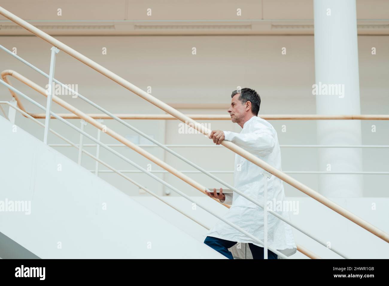 Wissenschaftler, der sich auf der Treppe in der medizinischen Klinik aufbewegt Stockfoto