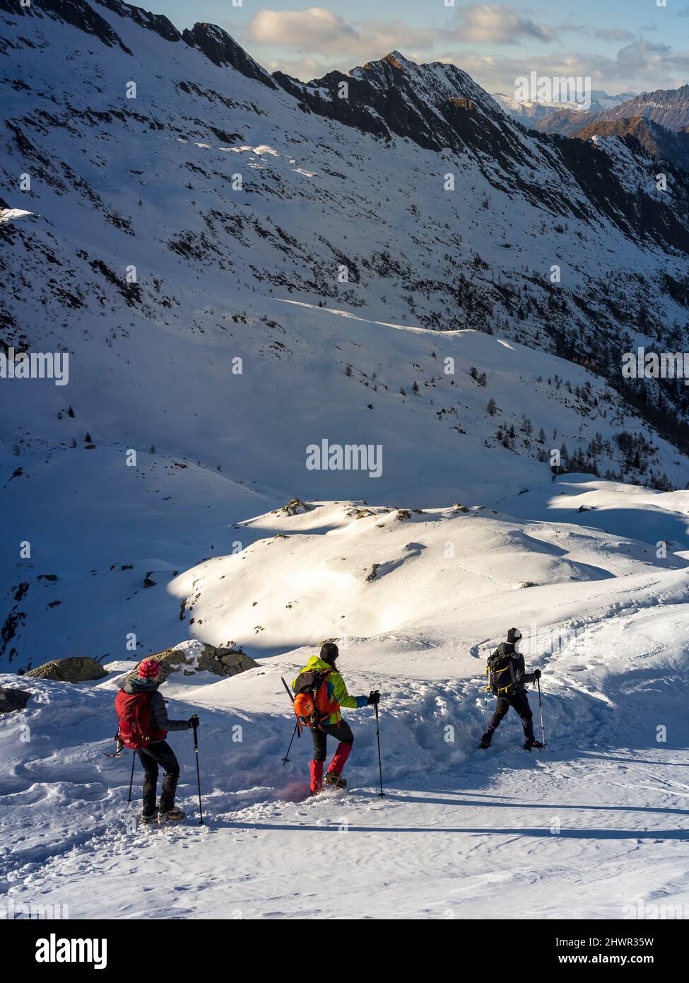 Ski-Bergsportler folgen einander zu Fuß auf verschneiten Loipen in den Orobischen Alpen im Valtellina, Italien Stockfoto