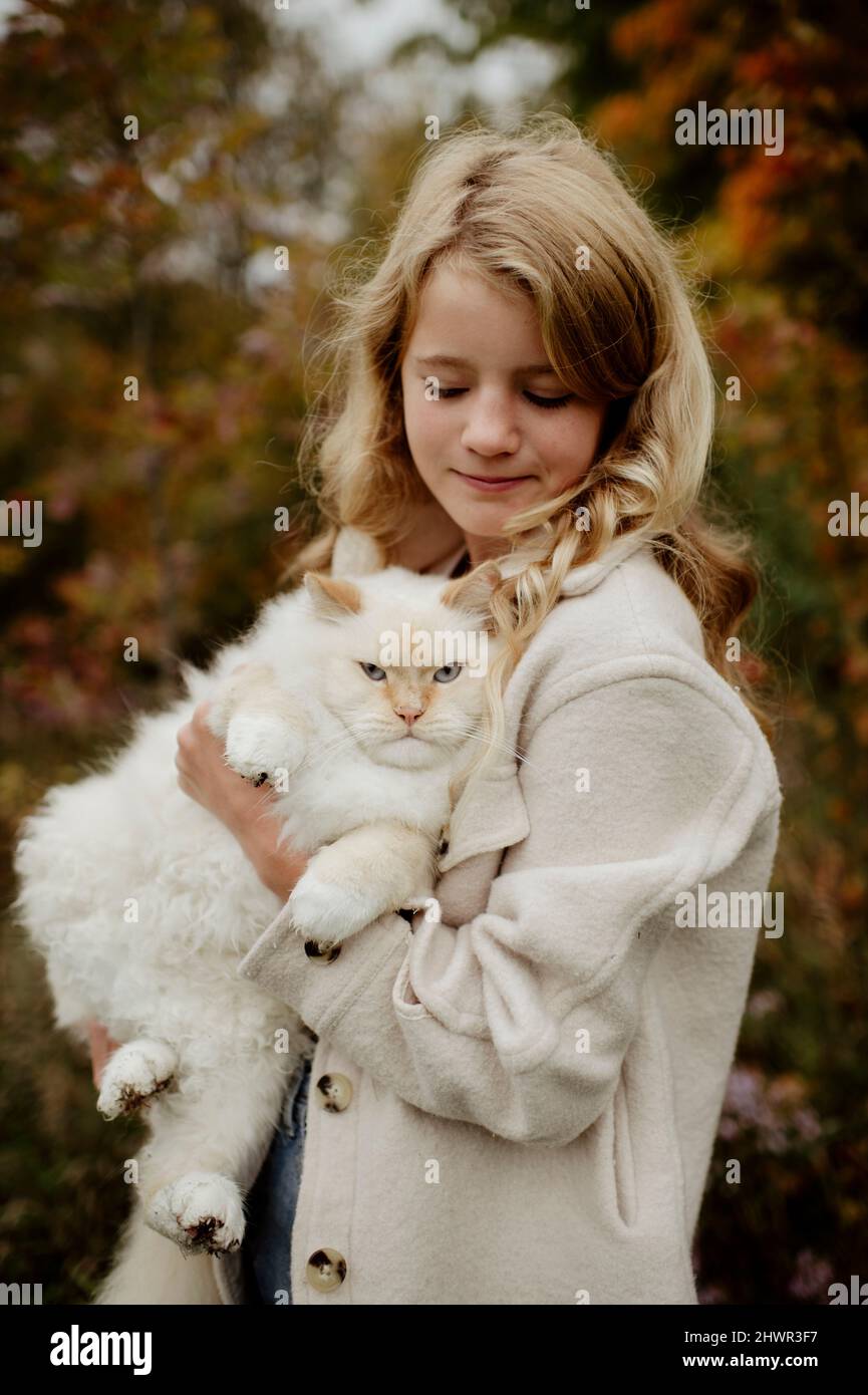 Blonde Mädchen tragen Ragdoll Katze im Garten Stockfoto