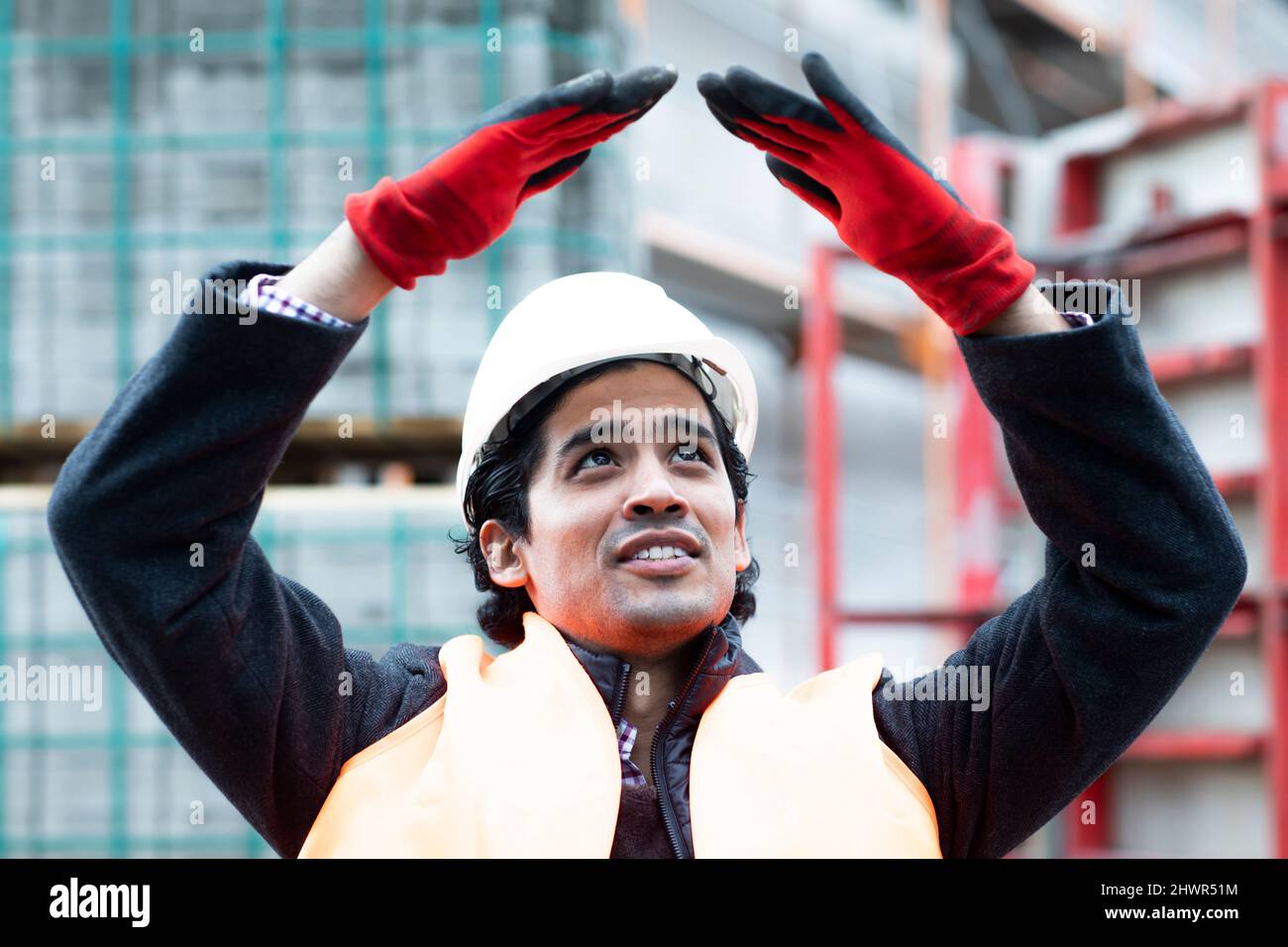 Ingenieur mit erhobenen Armen, die im Freien gestikulieren Stockfoto
