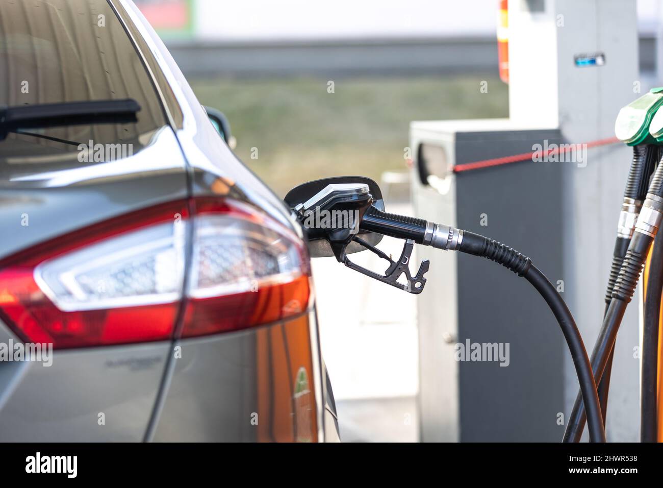 Hohe Preise für Benzin und Dieselkraftstoff an der Tankstelle, junge Frau betankt das Auto, Wirtschaftskrise Konzept Stockfoto