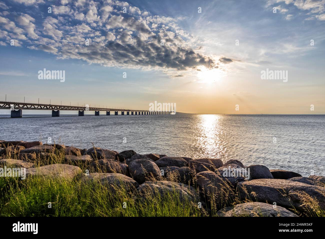 Oresund Bridge bei Sonnenuntergang mit felsiger Küste im Vordergrund Stockfoto