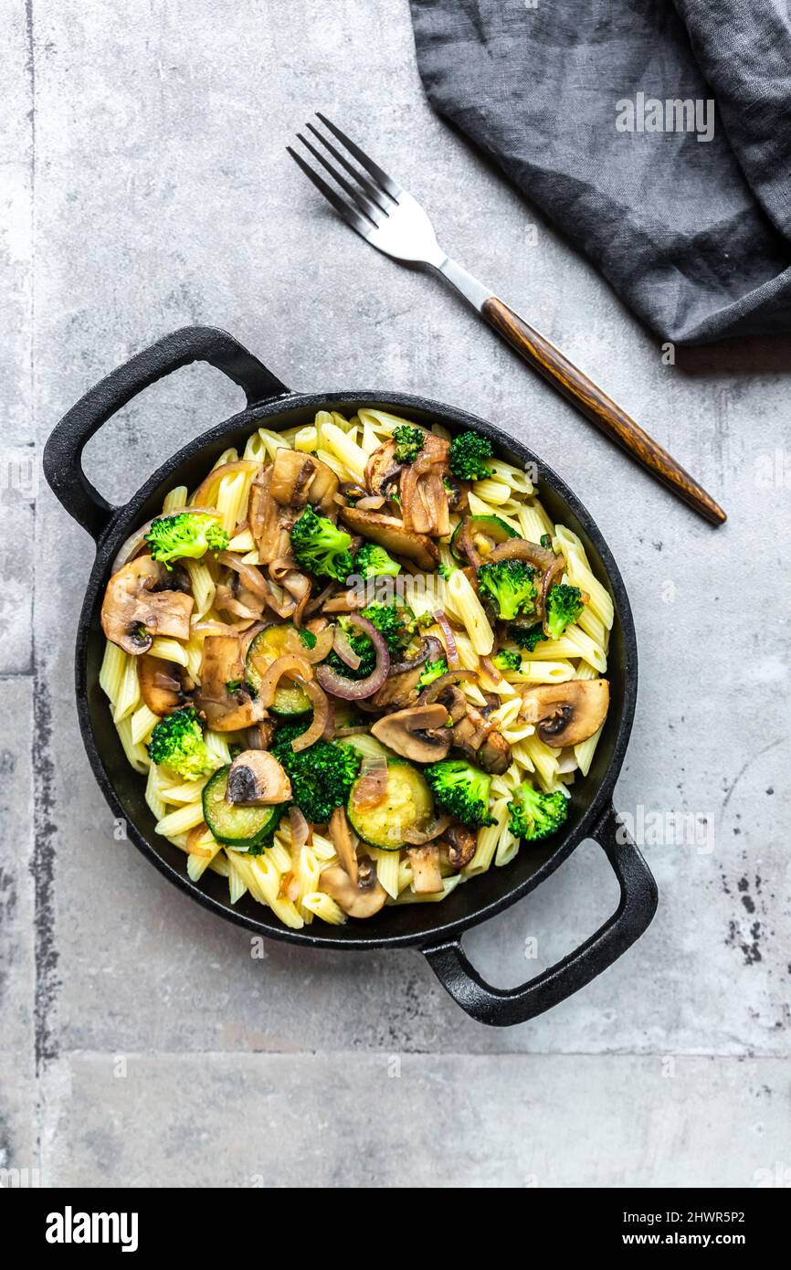 Penne mit Pilzen, Brokkoli, Zucchini und Zwiebeln Stockfoto