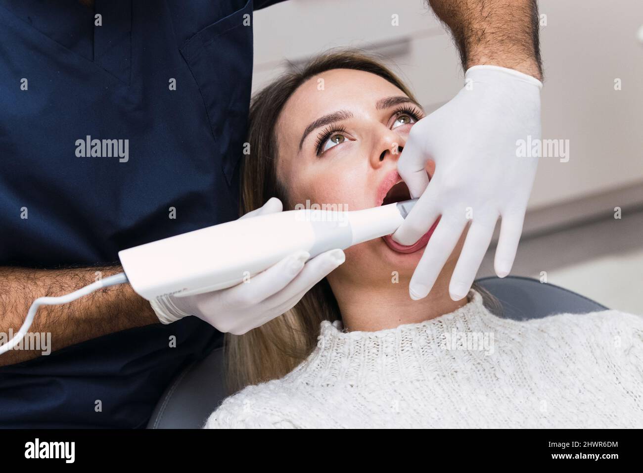 Zahnarzt mit intraoralem Scanner, der die Zähne des Patienten in der Klinik untersucht Stockfoto