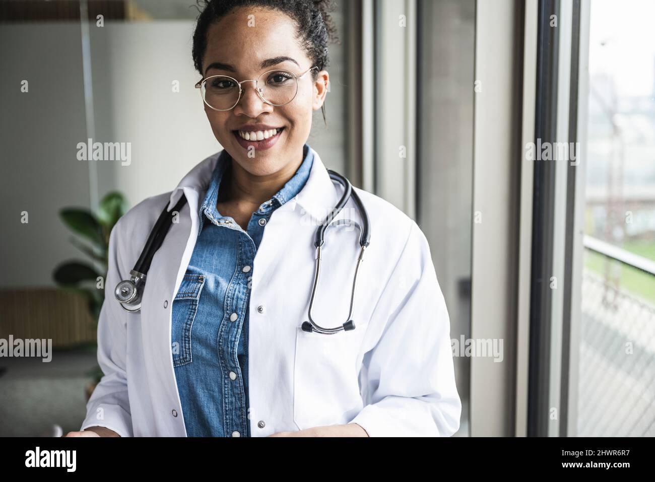 Lächelnder Arzt mit Stethoskop um den Hals im Krankenhaus Stockfoto