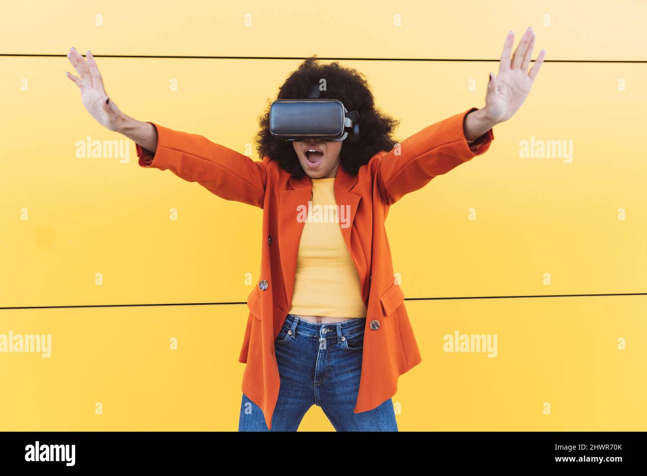 Frau mit VR-Brille macht Stop-Geste vor der Wand Stockfoto