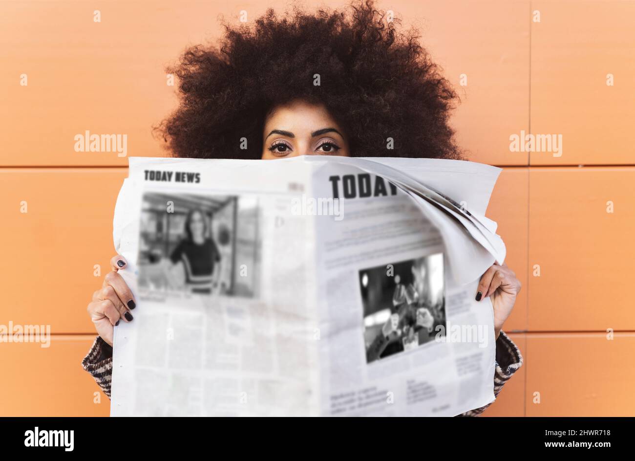 Frau mit Zeitung vor der Wand Stockfoto