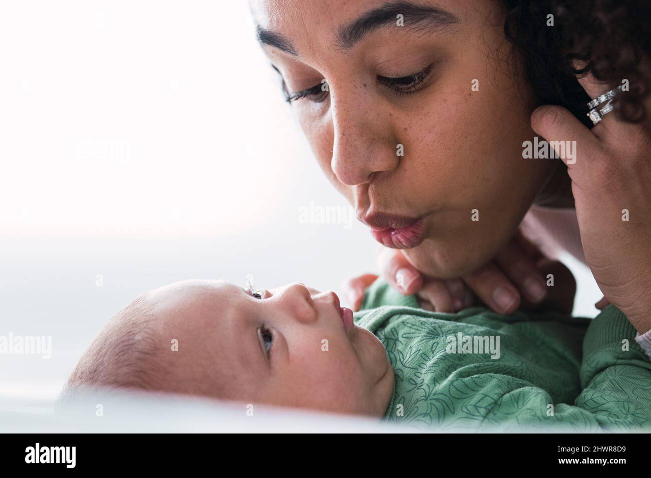 Mutter puckert und schaut auf Baby Junge Stockfoto
