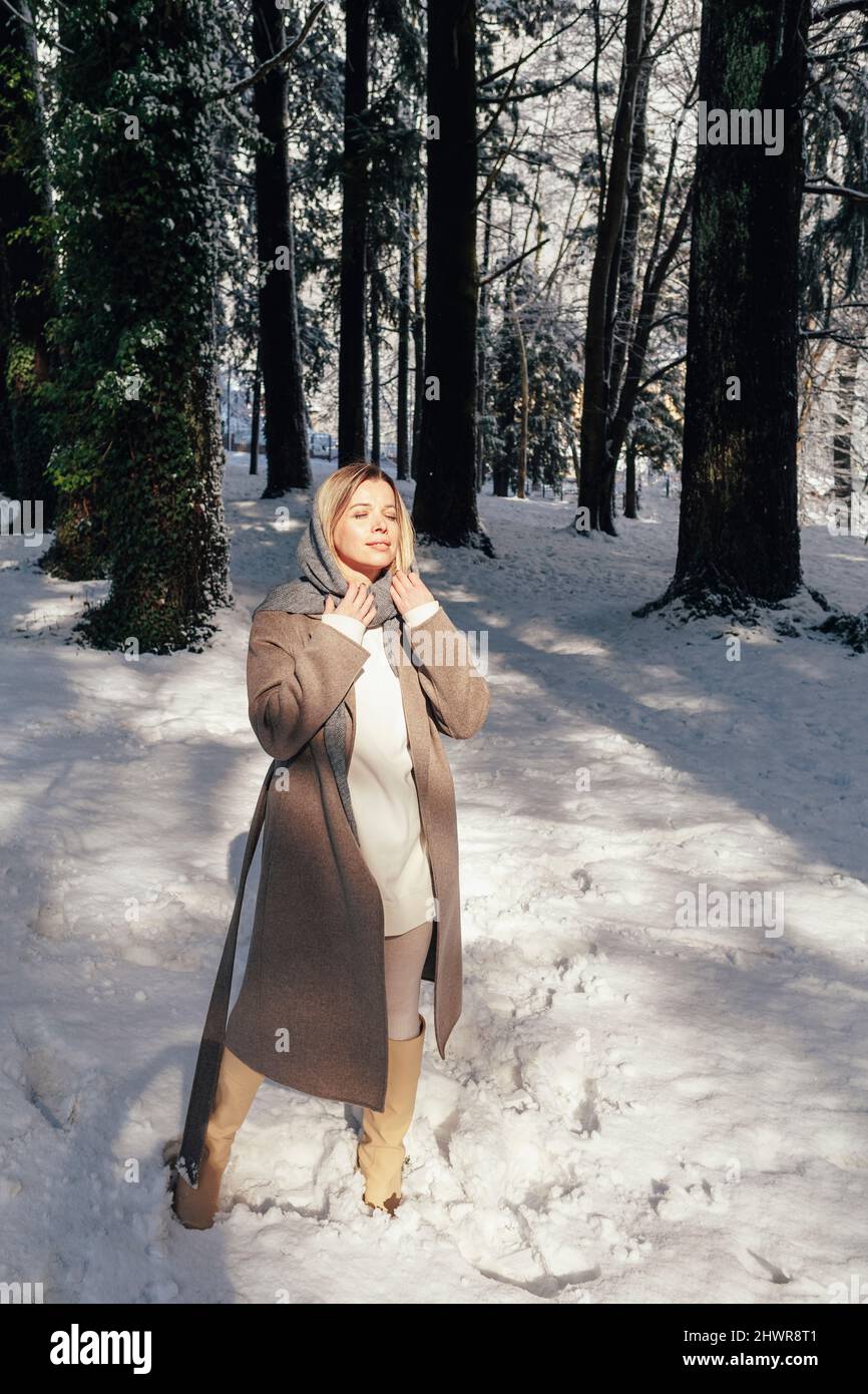 Frau in warmer Kleidung, die Freizeit im Winterwald verbringt Stockfoto