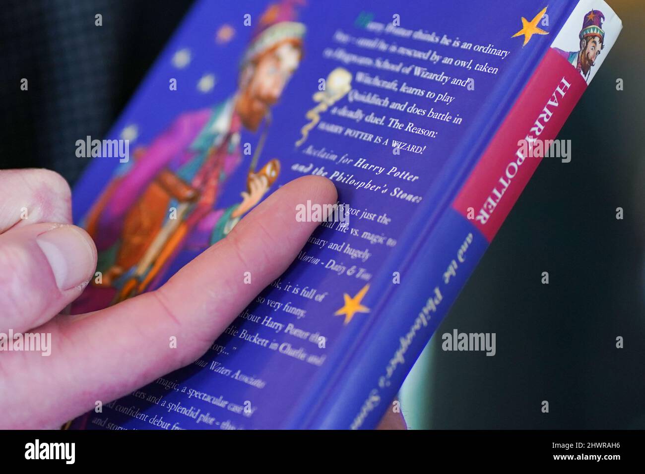 Der Auktionator Jim Spencer zeigt einen Fehler, der nur bei Erstauflagenkopien von JK Rowlings Harry Potter und der Stein der Weisen auftritt, den Rechtschreibfehler von Philisophers auf der Rückseite. Das makellose Buch ist eines von nur 500, die 1997 in der ersten Auflage produziert wurden und bei Hansons' Auctioneers in der Bishton Hall, Staffordshire, zu sehen sind. Das Buch wurde nie gelesen und wurde 25 Jahre lang in einer Schutzhülle in Dunkelheit gehalten und konnte bis zu £100.000 holen, wenn es am 9. März bei der Hanson's Library Auction unter den Hammer geht. Bilddatum: Montag, 7. März 2022. Stockfoto