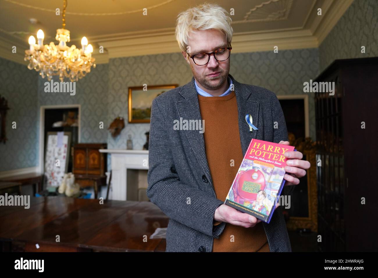 Der Auktionator Jim Spencer hält eine makellose Erstausgabe von JK Rowlings Harry Potter und der Stein der Weisen, einer von nur 500 Exemplaren, die 1997 in der ersten Auflage produziert wurden und bei Hansons' Auctioneers in der Bishton Hall, Staffordshire, zu sehen ist. Das Buch wurde nie gelesen und wurde 25 Jahre lang in einer Schutzhülle in Dunkelheit gehalten und konnte bis zu £100.000 holen, wenn es am 9. März bei der Hanson's Library Auction unter den Hammer geht. Bilddatum: Montag, 7. März 2022. Stockfoto