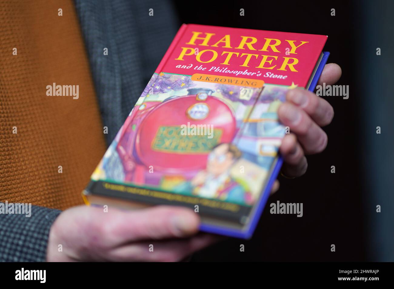 Der Auktionator Jim Spencer hält eine makellose Erstausgabe von JK Rowlings Harry Potter und der Stein der Weisen, einer von nur 500 Exemplaren, die 1997 in der ersten Auflage produziert wurden und bei Hansons' Auctioneers in der Bishton Hall, Staffordshire, zu sehen ist. Das Buch wurde nie gelesen und wurde 25 Jahre lang in einer Schutzhülle in Dunkelheit gehalten und konnte bis zu £100.000 holen, wenn es am 9. März bei der Hanson's Library Auction unter den Hammer geht. Bilddatum: Montag, 7. März 2022. Stockfoto